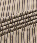 Close-up of Brookhaven Rockport fabric draped in gentle folds, revealing charcoal grey and taupe stripes with cream detailing and a textured woven appearance.