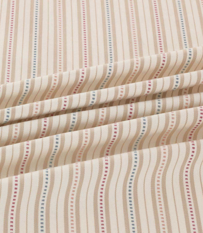 Brookhaven Shell striped fabric arranged in soft folds, highlighting delicate blush pink, muted blue and terracotta stripes with decorative dotted detailing.