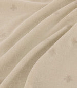 Bumblebee Linen fabric arranged in gentle folds, showing small tonal beige embroidered bumblebees and the natural linen-look woven texture.