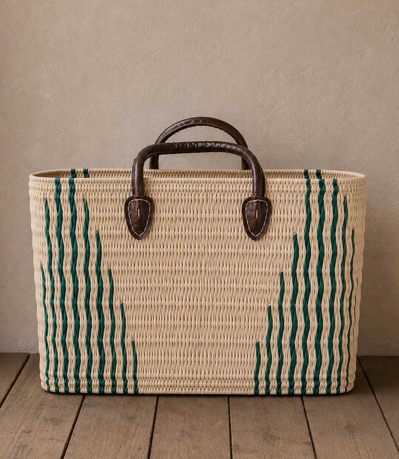 Woven basket tote bag with green stripes and brown leather handles