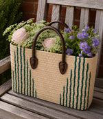 Woven basket tote bag with green stripes and brown leather handles