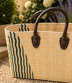 Woven basket tote bag with green stripes and brown leather handles