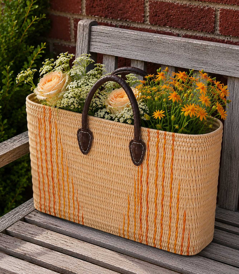 Woven basket tote bag with orange stripes and brown leather handles
