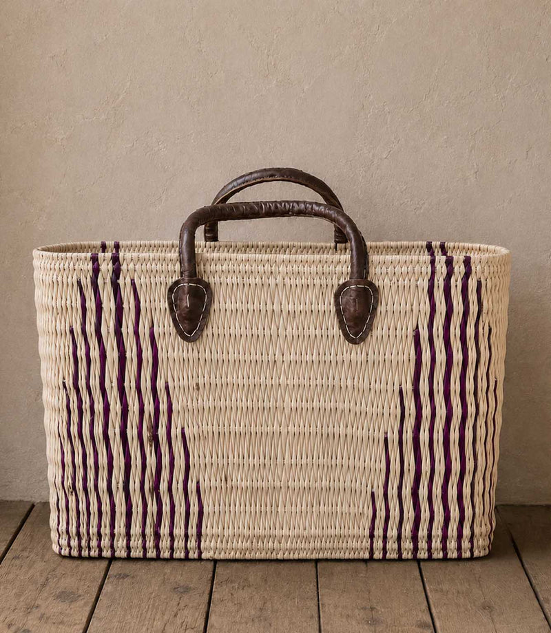 Woven basket tote bag with purple stripes and brown leather handles