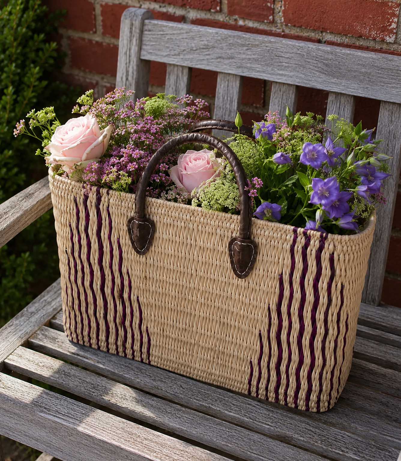 Woven basket tote bag with purple stripes and brown leather handles