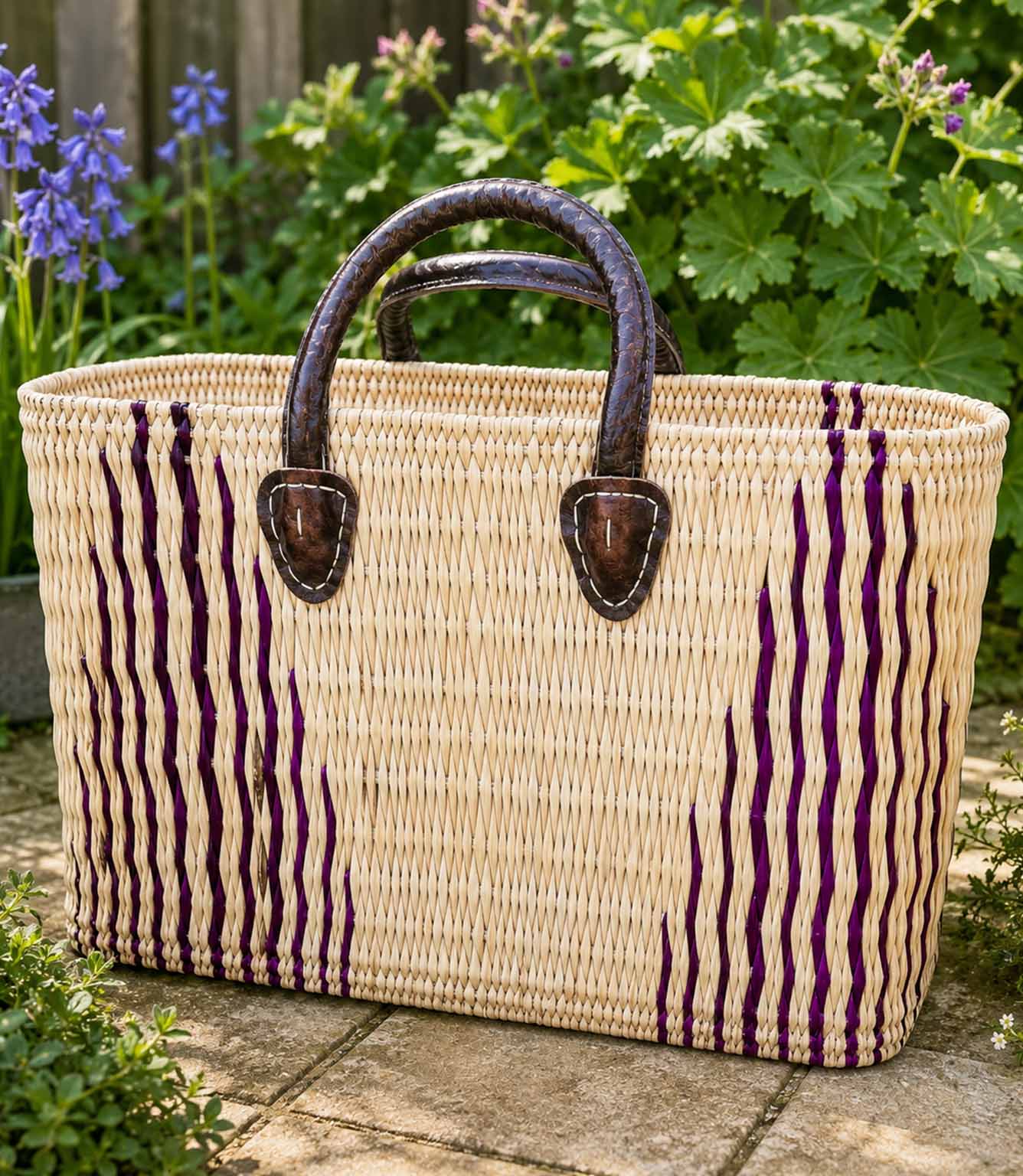Woven basket tote bag with purple stripes and brown leather handles