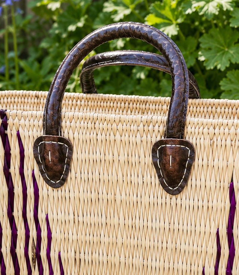 Woven basket tote bag with purple stripes and brown leather handles