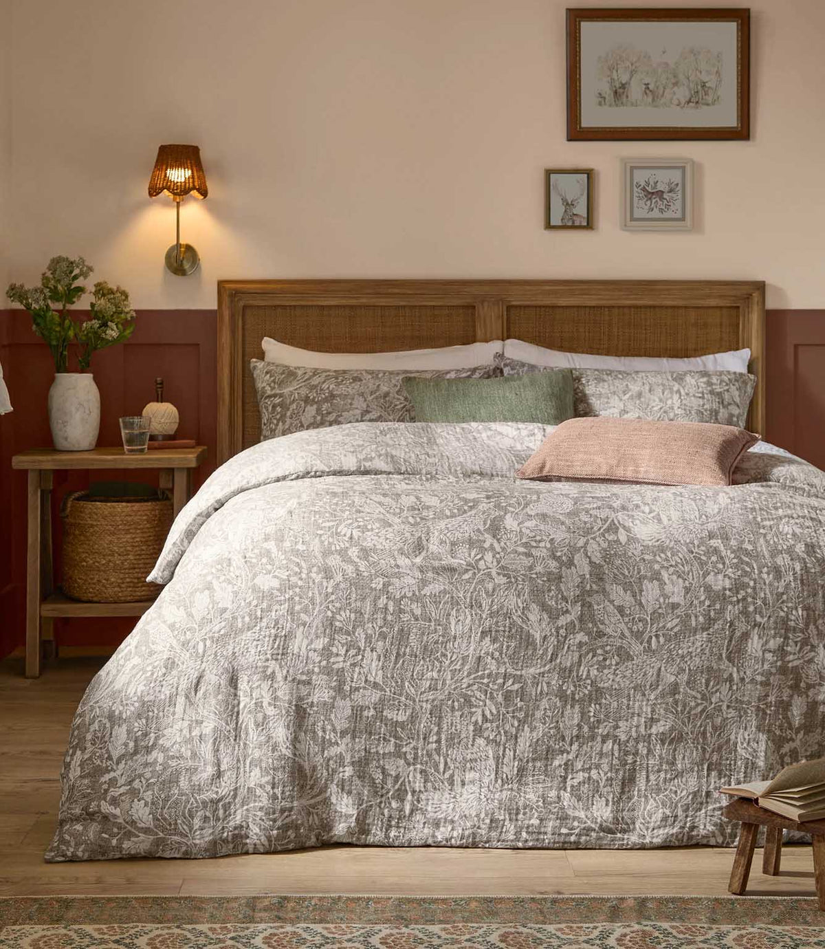 Voyage Maison Cademuir Reversible Muslin Duvet Cover Set in Nut, styled on a wooden bed with grey-brown woodland print bedding and coordinating cushions.