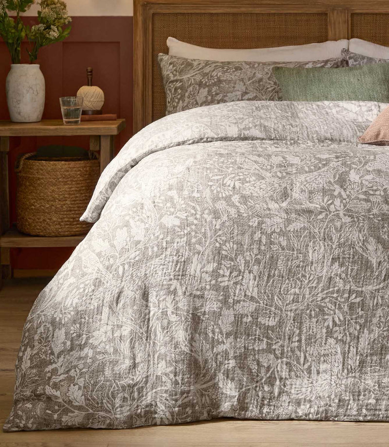 Cademuir Reversible Muslin Duvet Cover Set in Nut by Voyage Maison, styled with matching pillowcases and contrasting green and blush cushions.