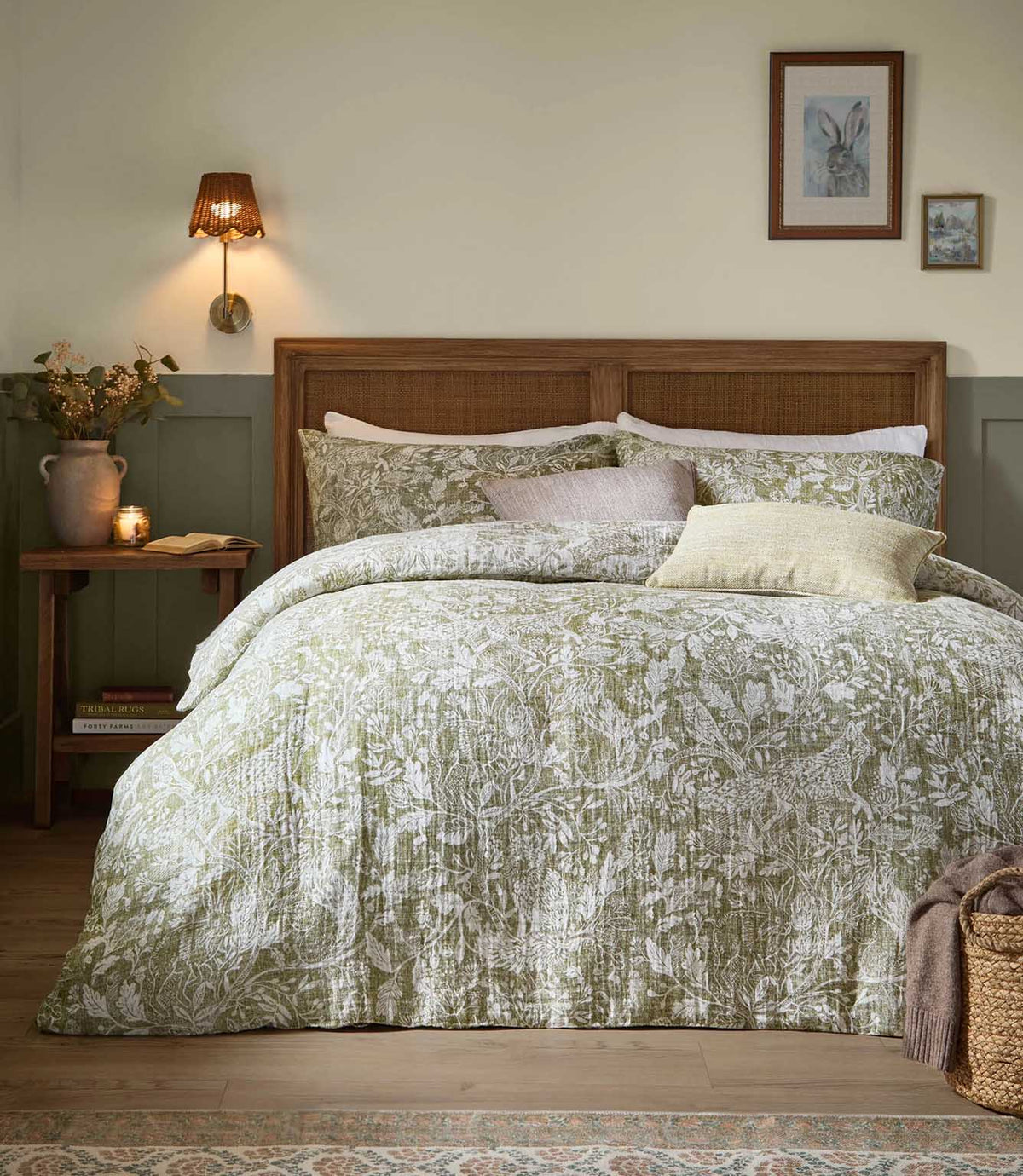 Voyage Maison Cademuir Reversible Muslin Duvet Cover Set in green, styled on a wooden bed with coordinating cushions in a country-inspired bedroom.
