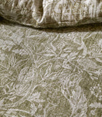 Detailed close-up of Voyage Maison Cademuir bedding in green and white, highlighting the intricate woodland design of birds, leaves and botanical motifs.