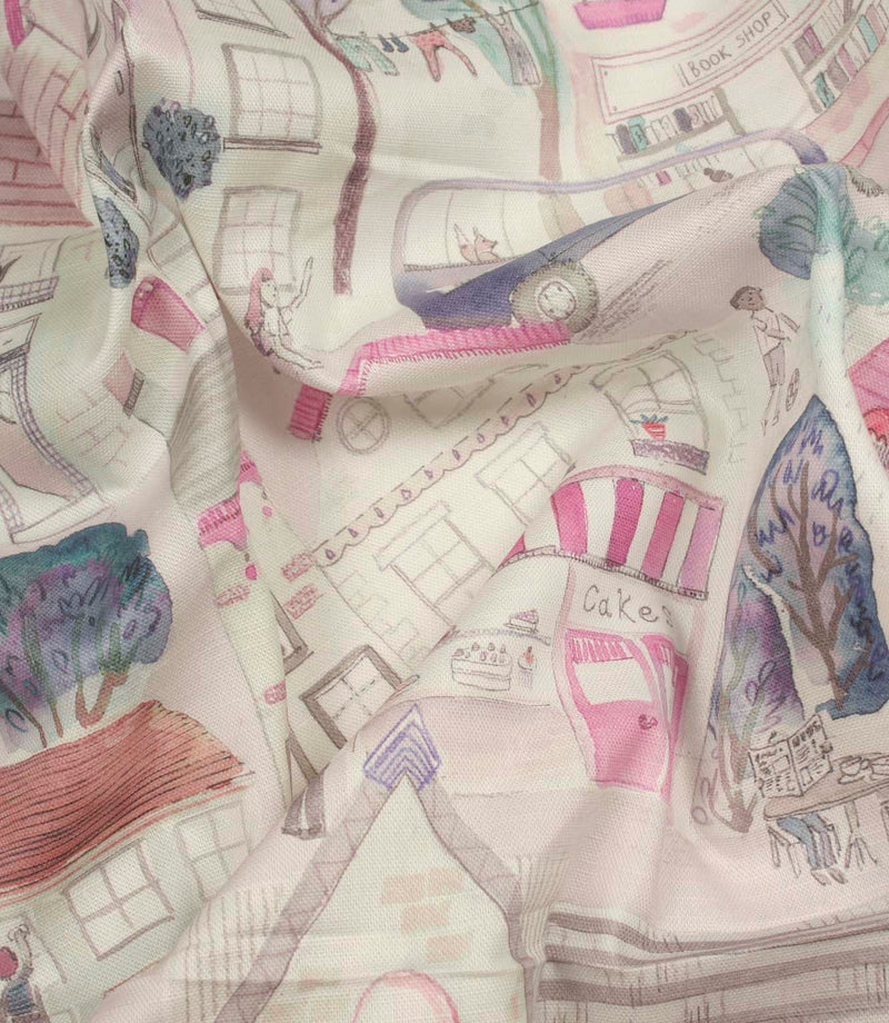 Draped Cakes & More cotton fabric showing the natural texture and illustrated neighbourhood design in purple and pink tones.