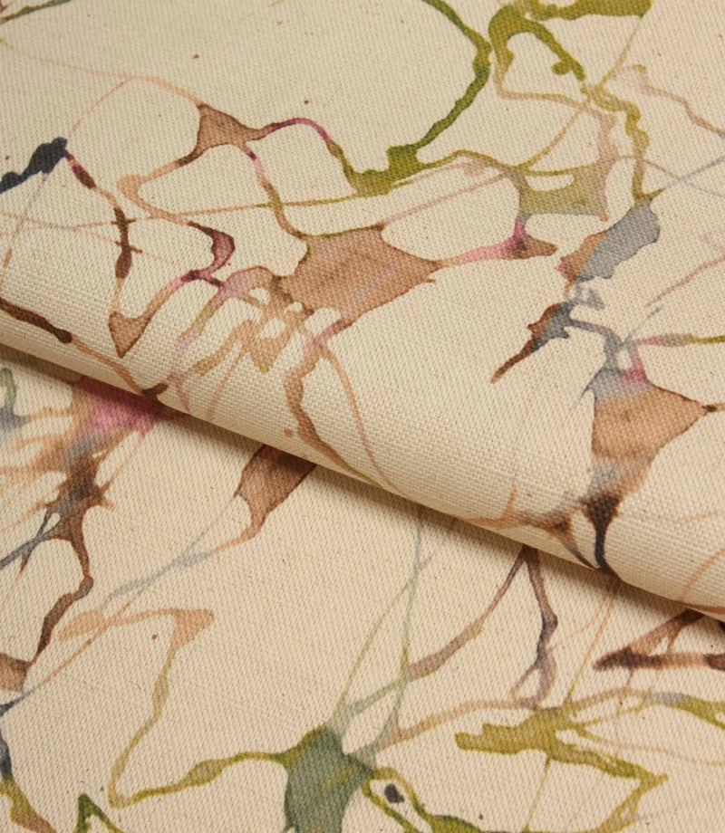 Folded Carrara fabric displaying the natural cotton linen texture and flowing abstract design in green, pink, blue and beige tones.