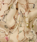Draped Carrara cotton linen fabric showing the elegant handle and contemporary abstract pattern in green, pink, blue and neutral shades.