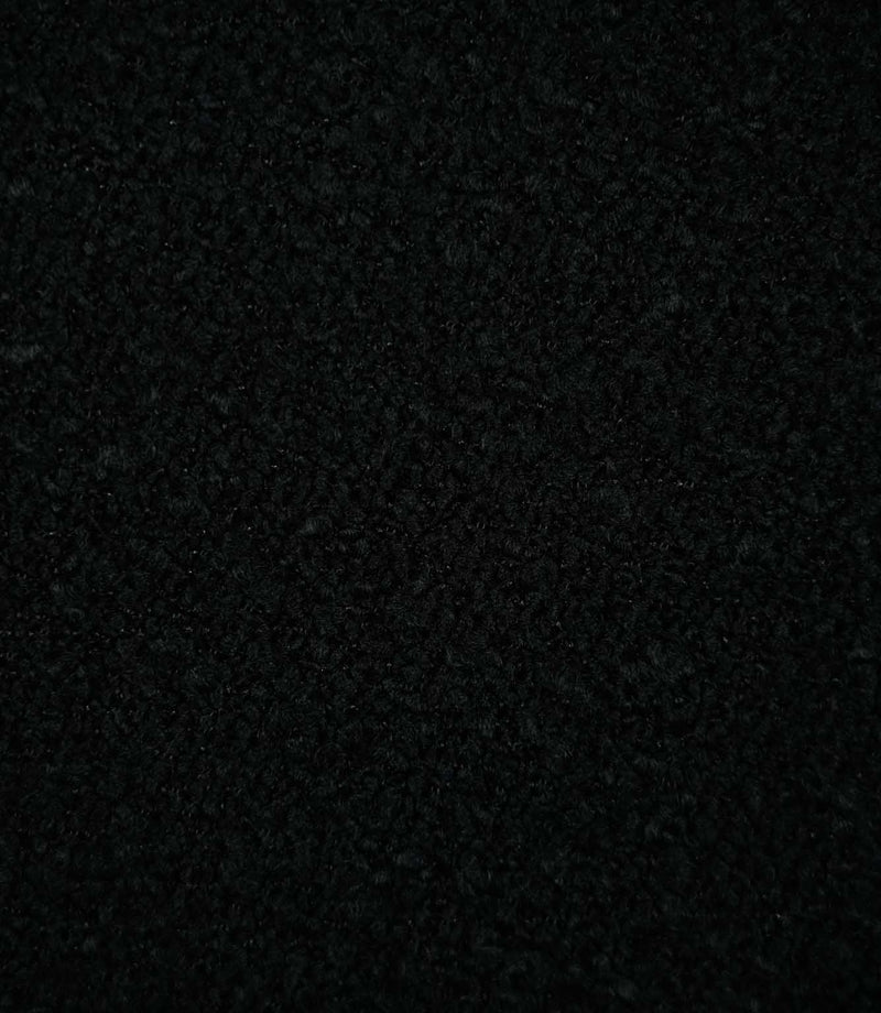 Close-up of Case Bouclé Noir upholstery fabric in deep black, showing its dense looped bouclé weave and richly textured surface.