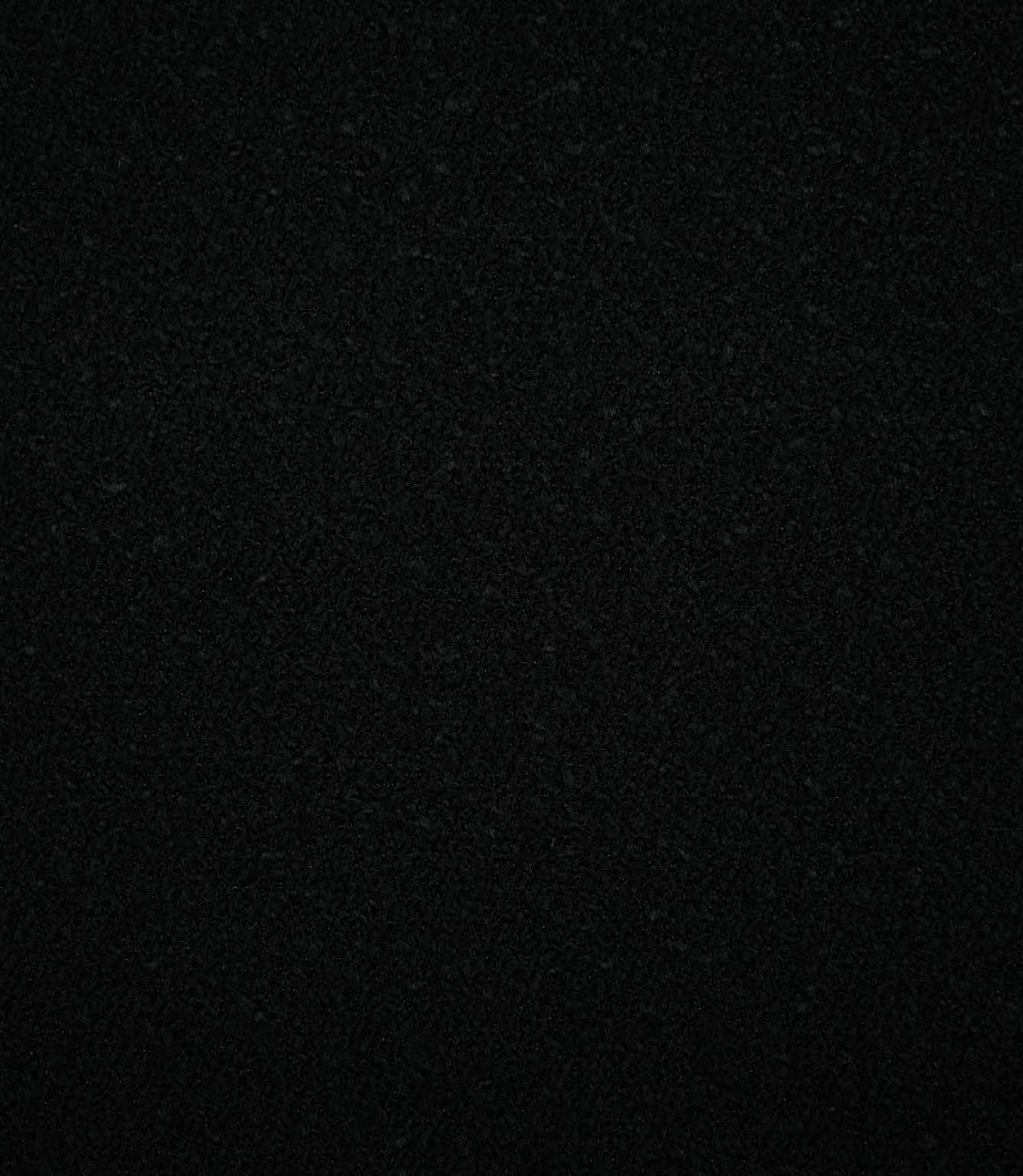 Full-frame view of Case Bouclé Noir black upholstery fabric, highlighting the plain design and soft, tightly woven bouclé texture.