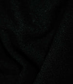 Case Bouclé Noir upholstery fabric draped into soft folds, showcasing its black colour, flexible handle and tactile looped texture.