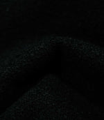 Macro detail of draped Case Bouclé Noir fabric, highlighting the dense black bouclé texture and softly structured folds of the upholstery material.