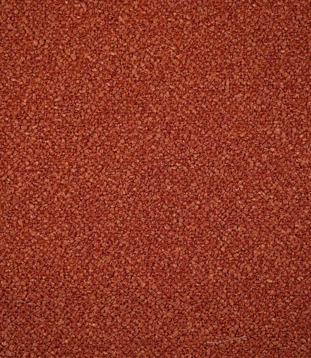 Full-frame view of Case Bouclé terracotta upholstery fabric, highlighting the plain design, warm earthy tone and tactile looped surface.