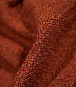 Macro detail of Case Bouclé fabric in terracotta, showing the raised looped yarns and densely textured woven surface of the upholstery fabric.