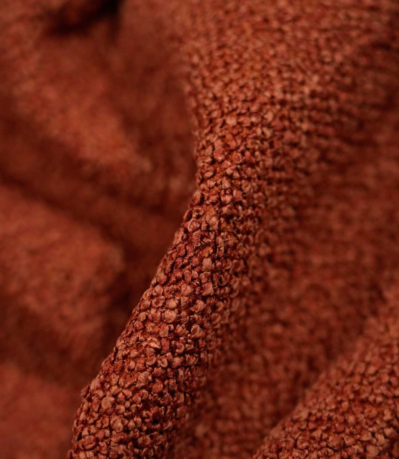 Macro detail of Case Bouclé fabric in terracotta, showing the raised looped yarns and densely textured woven surface of the upholstery fabric.