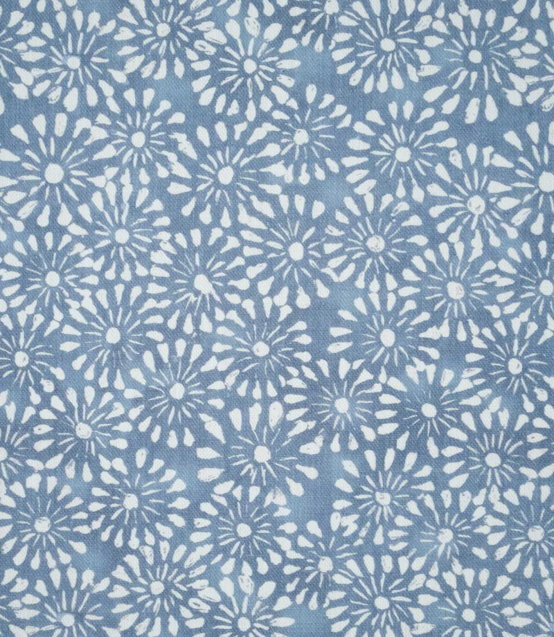 Close-up of Chamberry Bluebell fabric featuring a small-scale floral print of white daisy-like flowers with delicate petals and fine radiating details on a soft, muted blue background.