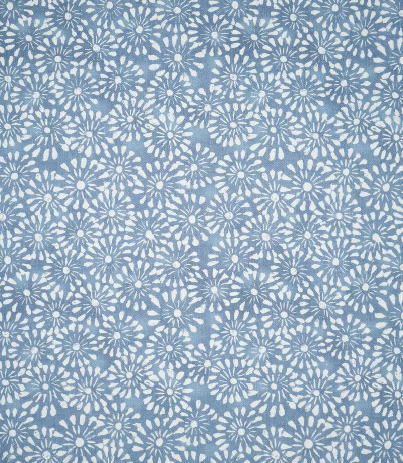 Chamberry Bluebell floral fabric displaying a repeating all-over pattern of small white daisy-inspired flowers on a dusty blue background, showing the contemporary design and closely arranged blooms.