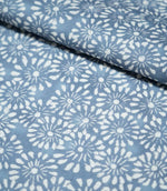 Chamberry Bluebell fabric folded over itself, showing the delicate white floral print against a muted blue background and the fabric's lightly textured surface.