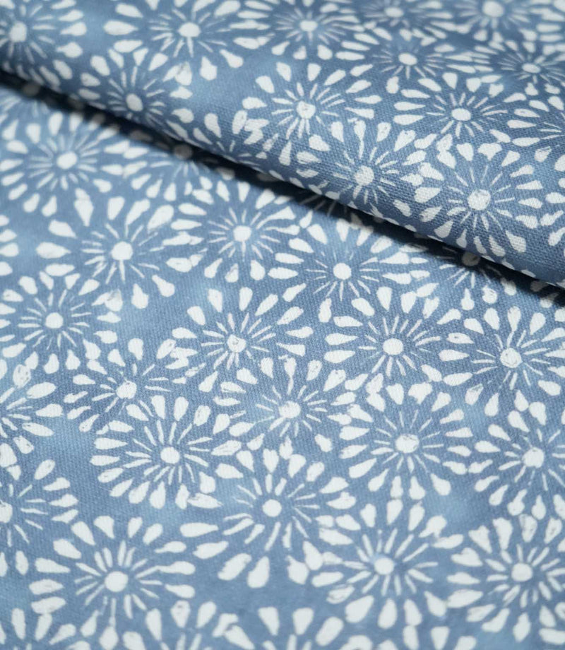 Chamberry Bluebell fabric folded over itself, showing the delicate white floral print against a muted blue background and the fabric's lightly textured surface.