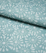 Close-up of Chamberry Duck Egg fabric folded over itself, showing the delicate white daisy-like floral pattern, muted duck egg background and fine woven texture.