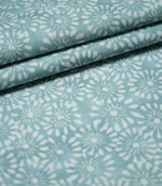 Chamberry Duck Egg floral fabric arranged in overlapping folds, highlighting the repeating white flower motifs, soft blue-green background and lightly textured woven finish.