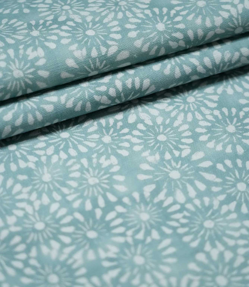 Chamberry Duck Egg floral fabric arranged in overlapping folds, highlighting the repeating white flower motifs, soft blue-green background and lightly textured woven finish.