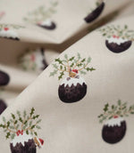 1. Detailed close-up of Christmas Pudding Neutral fabric featuring a small mouse in a red festive hat peeking from a Christmas pudding topped with icing and holly.