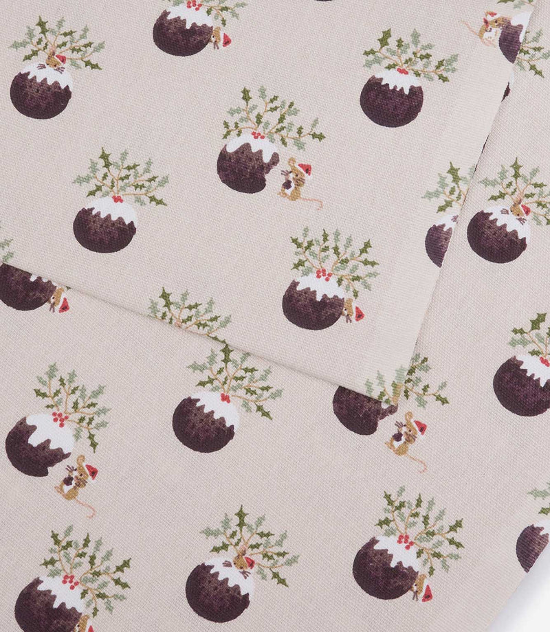 A close-up of patterned fabric showing a repeating print of Christmas puddings, holly leaves, mistletoe, and small mice on a light warm beige background.