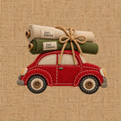 Embroidered patch of a red vintage car carrying two rolled fabric samples labeled 'Just Fabrics' tied with a rope, on a beige burlap-textured background.