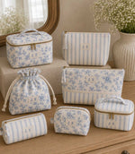 Blue ditsy floral and stripe fabric  makeup bags and pouches on a wooden cabinet