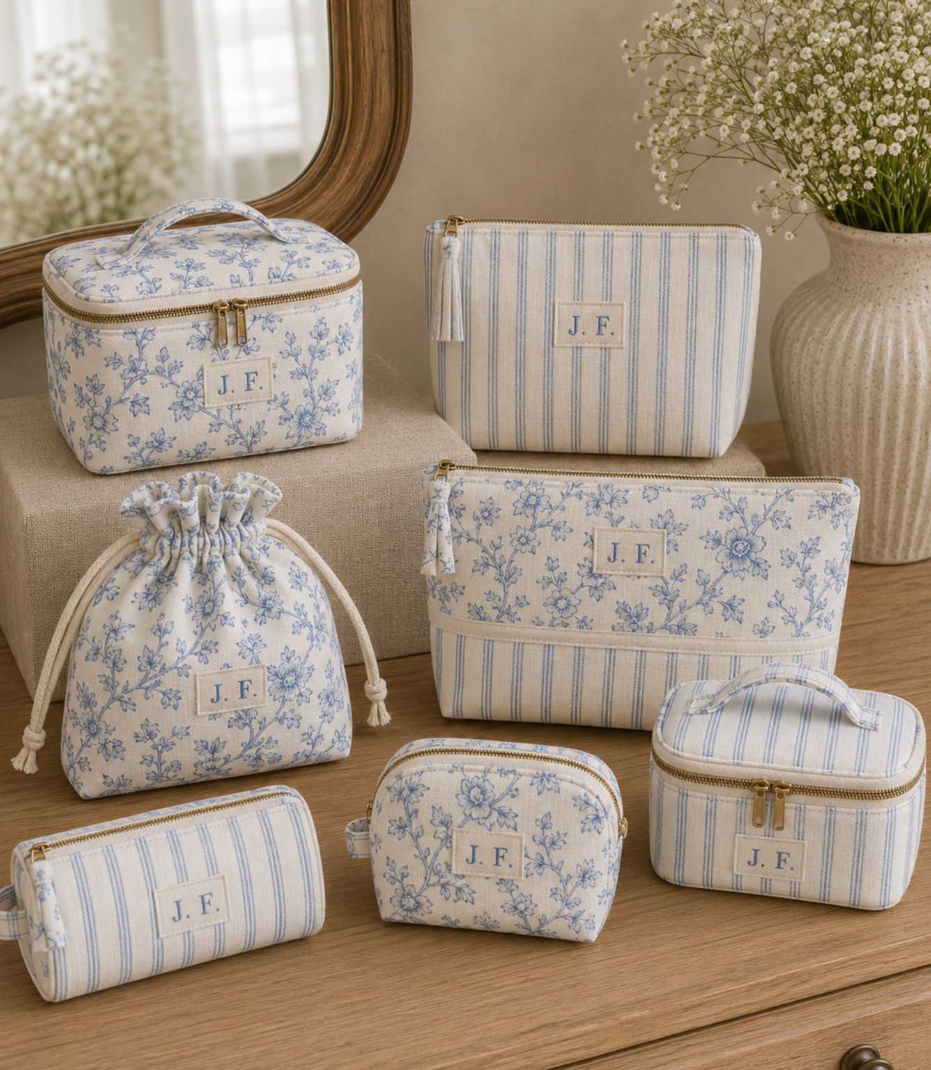 Blue ditsy floral and stripe fabric  makeup bags and pouches on a wooden cabinet