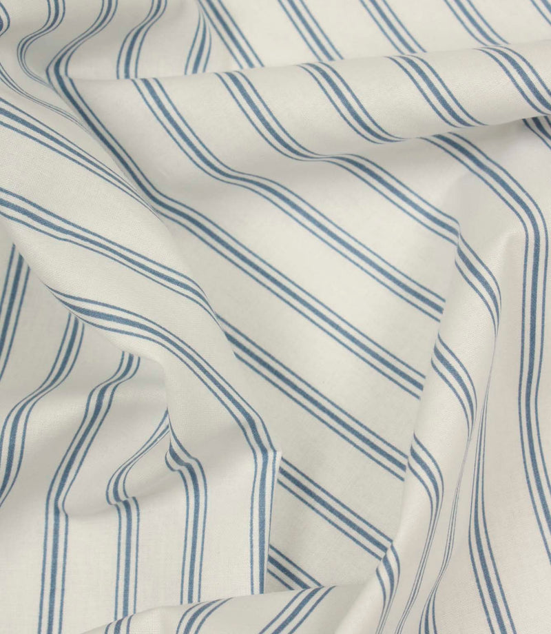 Draped striped fabric with soft blue vertical lines flowing across a natural ivory background.