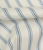 Folded blue ticking stripe fabric highlighting the smooth woven texture and classic narrow stripe detailing.