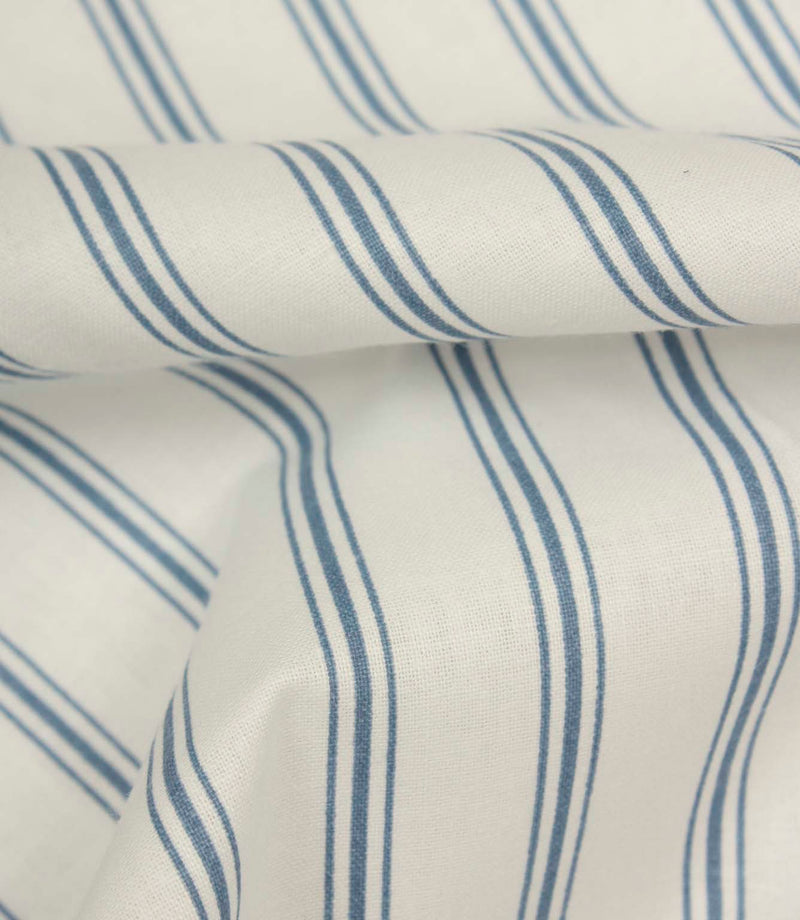 Folded blue ticking stripe fabric highlighting the smooth woven texture and classic narrow stripe detailing.
