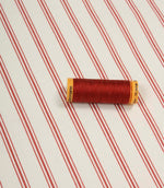 Red striped fabric laid flat with a coordinating spool of red thread, highlighting the classic stripe design and smooth woven finish.