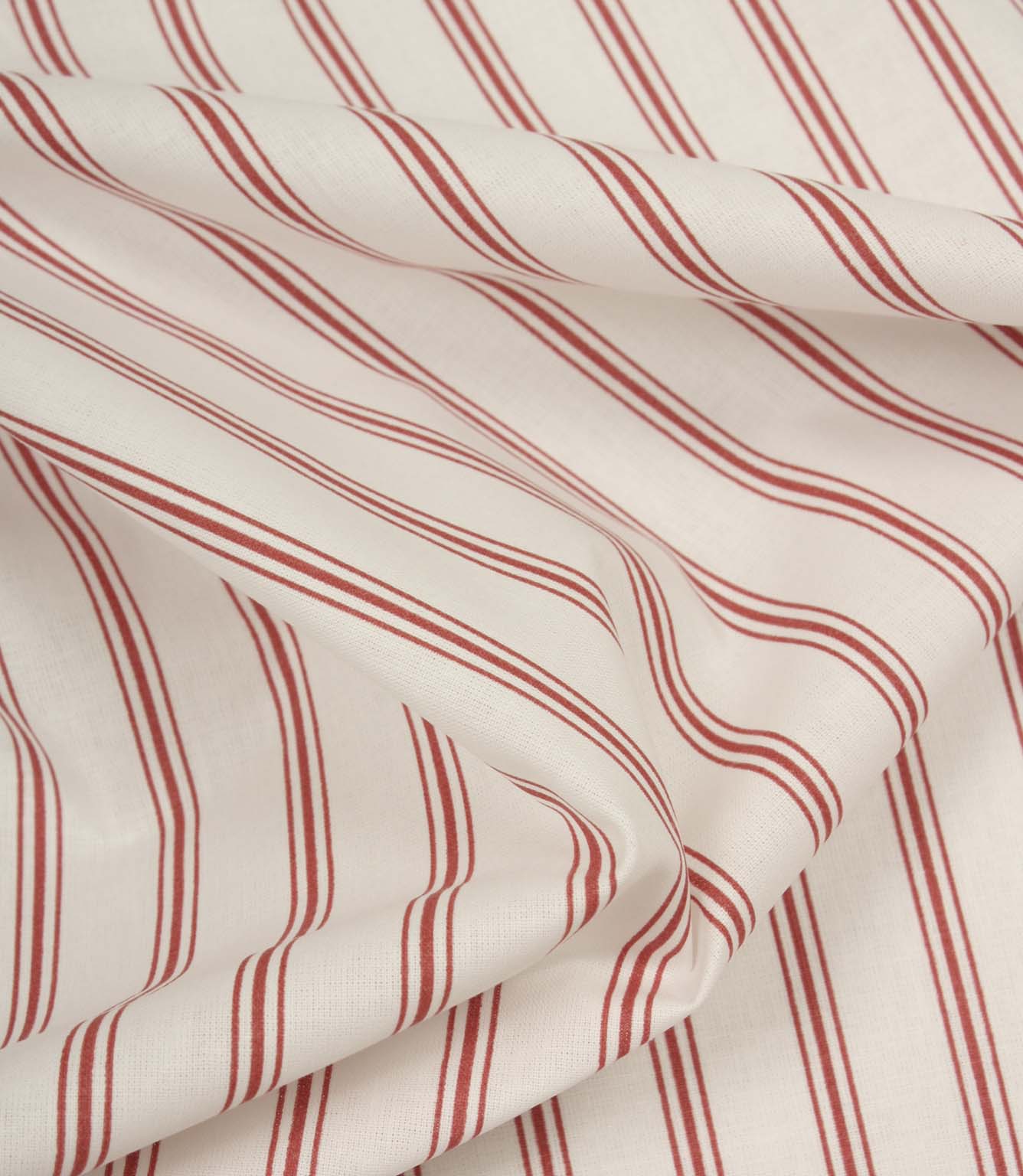 Softly folded ivory fabric with red ticking stripes, showing the gentle drape and lightweight woven texture.