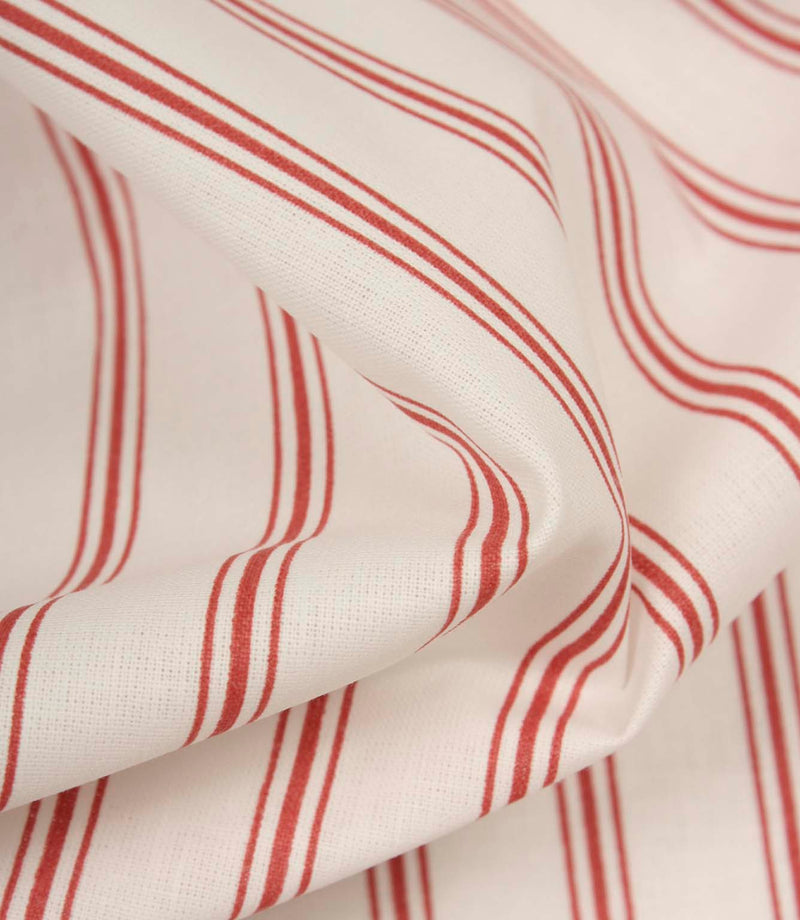 Detailed close-up of red striped fabric revealing the fine weave, soft handle, and timeless ticking stripe pattern.