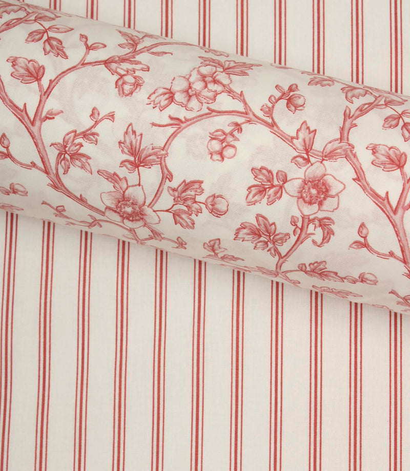 Red ticking stripe fabric paired with a coordinating floral fabric roll, styled to showcase complementary country-inspired designs.