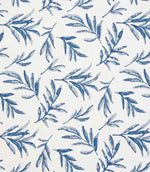 Close-up of embroidered floral upholstery fabric showing detailed leaf motifs in layered blue tones on a neutral base.