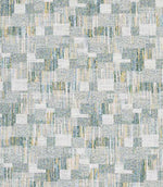 Close-up of woven geometric fabric with an abstract check pattern in soft sage green, pale blue and warm neutral tones, featuring a textured, layered weave.