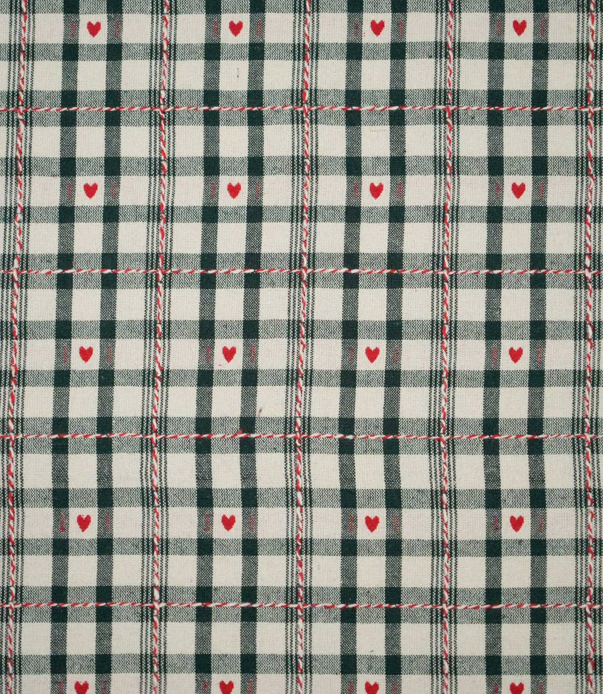 Cotswold Heart Tartan fabric in ivory and dark green, featuring a classic checked design with small red hearts and decorative red and white woven lines.