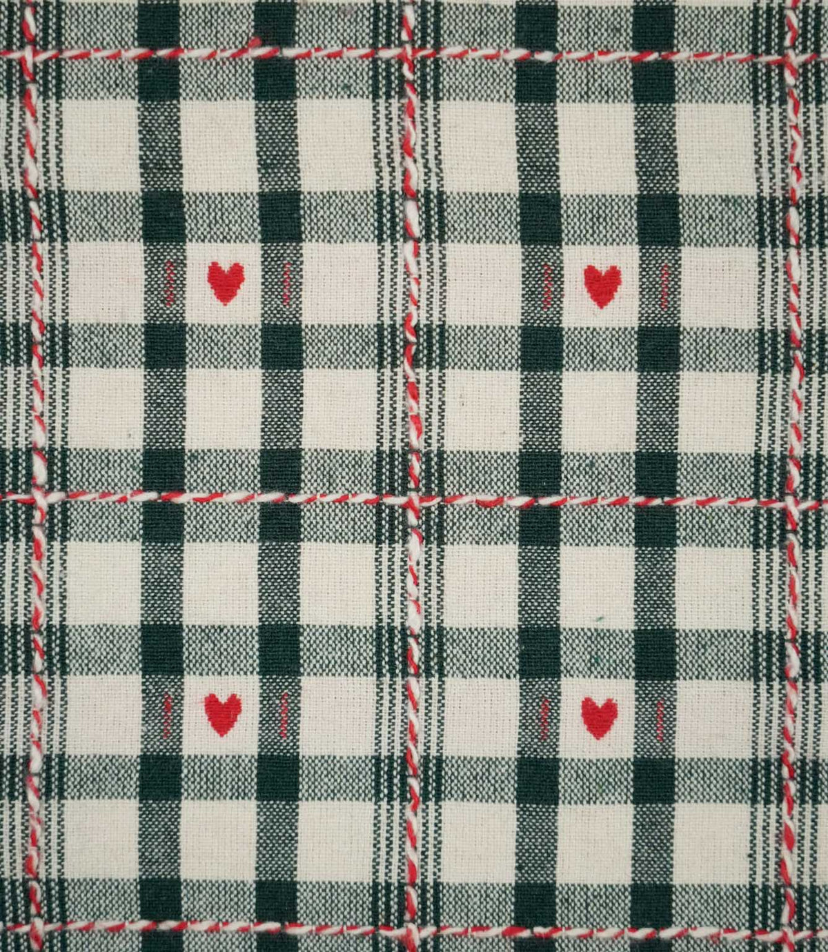 Close-up of Cotswold Heart Tartan ivory and green fabric, showing the woven check pattern, repeating red heart motifs and contrasting decorative thread detail.