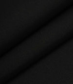Black woven fabric folded to show structure, weight, and smooth surface finish.