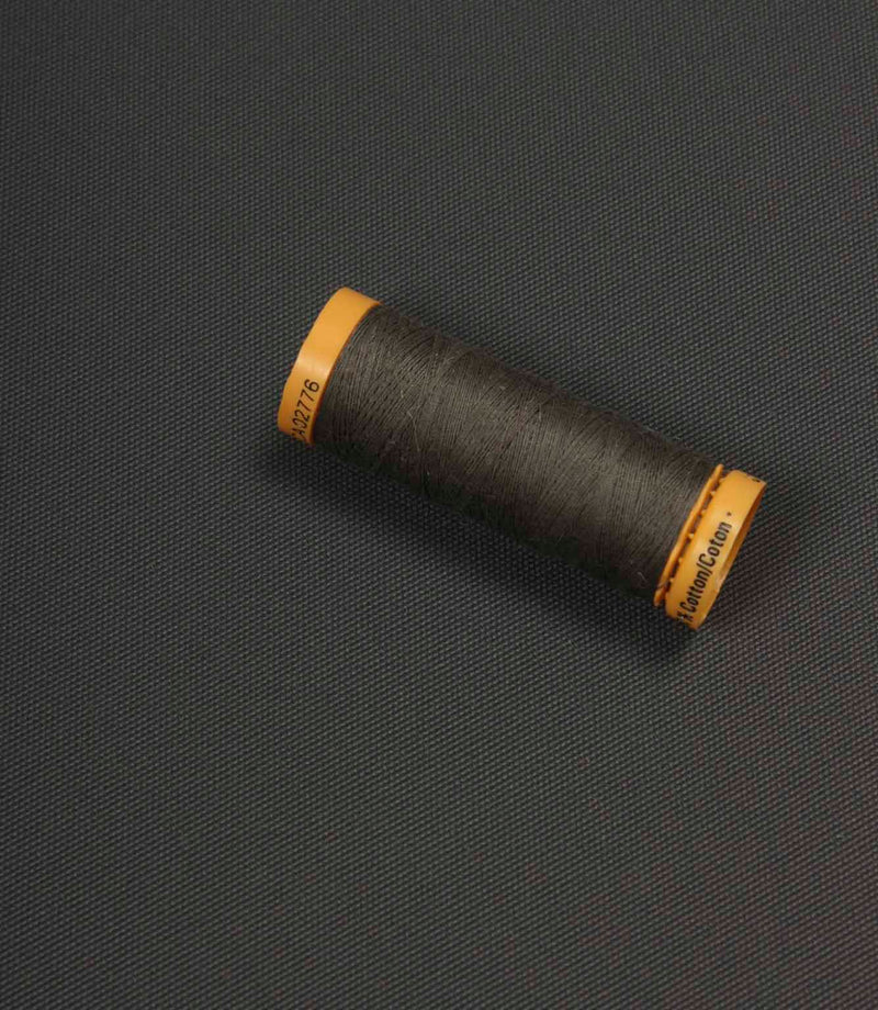 Charcoal grey fabric with a coordinating thread spool placed on top for colour comparison.